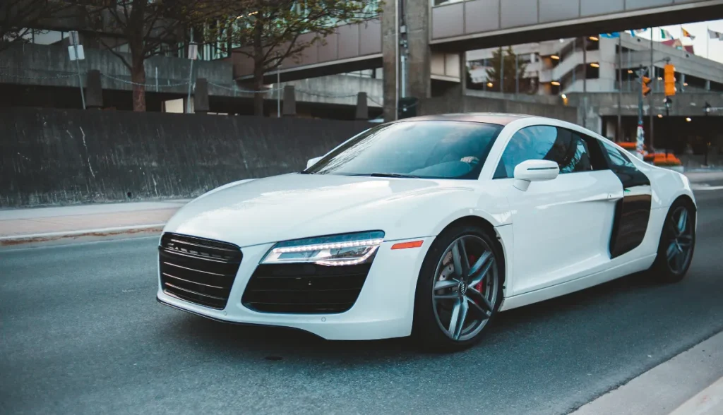 White Audi R8 sports car on an urban road, representing a vehicle that requires on-metal RFID tags for reliable performance.