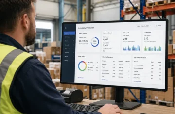 What Is Gen 2x RFID A Practical Guide for Brands and Manufacturers Warehouse worker reviewing Gen 2x RFID inventory dashboard showing real-time stock levels, inbound/outbound metrics, and product sales data on a monitor.