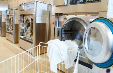 RFID Linen Tracking How Many Wash Cycles Can RFID Laundry Tags Really Survive Commercial laundry machines processing linens for RFID linen tracking operations.