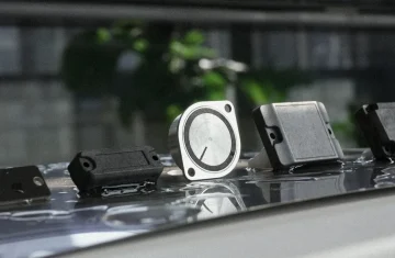 Best Outdoor RFID Tags for Asset Tracking A Buyer's Guide Assortment of rugged waterproof outdoor UHF RFID asset tracking tags resting on wet reflective surface.