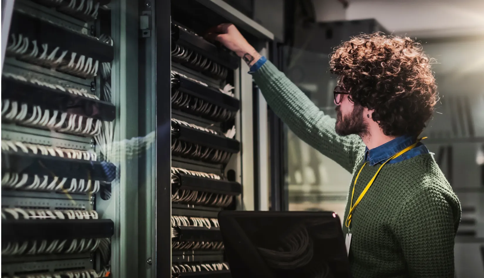 Smallest RFID Tag for Limited Installation Space On-Metal RFID Solutions for Small Assets IT technician maintaining network server rack in data center.