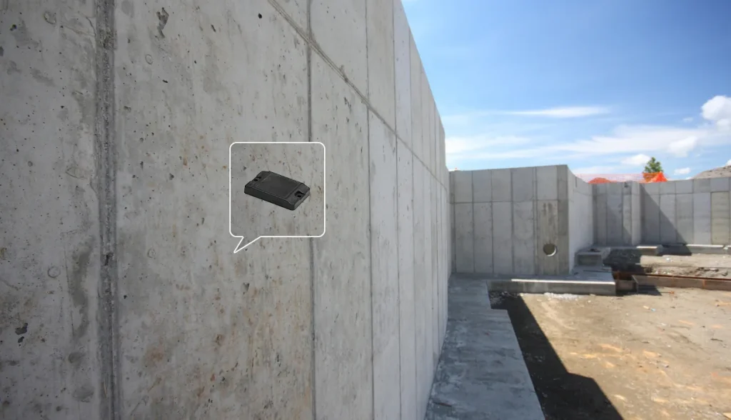 Finished cured concrete wall with call‑out graphic of embedded permanent RFID tag for long‑term concrete asset identification.