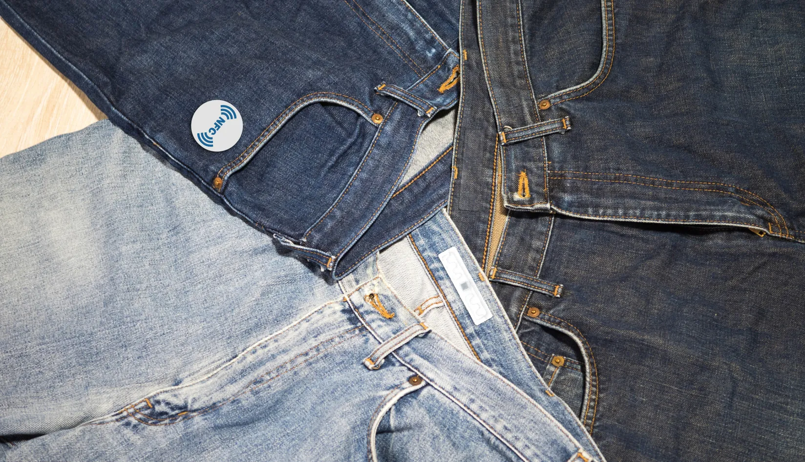RFID Tags for Garments What Makes a Tag Suitable for Clothing NFC and RFID garment tags attached on denim jeans for apparel inventory tracking.